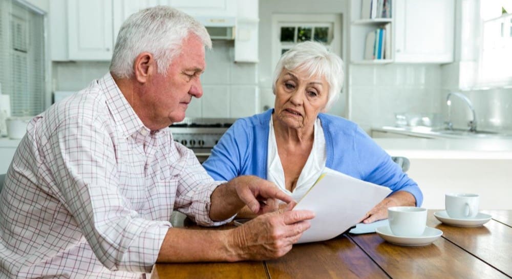 elderly-couple-looking-at-papers